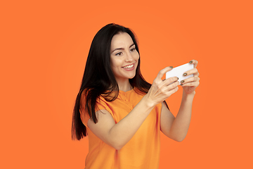 Image showing Caucasian young woman\'s portrait on orange background