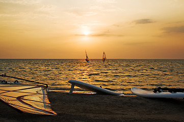 Image showing Silhouette of a two windsurfer on a gulf on a sunset