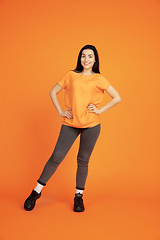 Image showing Caucasian young woman\'s portrait on orange background