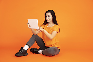 Image showing Caucasian young woman\'s portrait on orange background