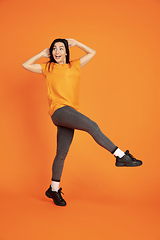 Image showing Caucasian young woman\'s portrait on orange background