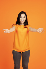 Image showing Caucasian young woman\'s portrait on orange background