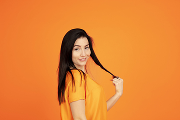 Image showing Caucasian young woman\'s portrait on orange background