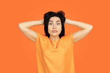 Image showing Caucasian young woman\'s portrait on orange background