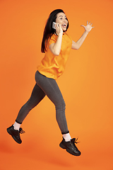 Image showing Caucasian young woman\'s portrait on orange background