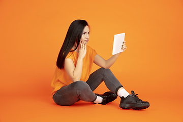 Image showing Caucasian young woman\'s portrait on orange background