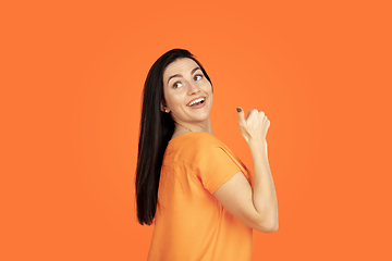 Image showing Caucasian young woman\'s portrait on orange background