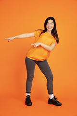 Image showing Caucasian young woman\'s portrait on orange background