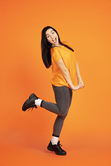 Image showing Caucasian young woman\'s portrait on orange background