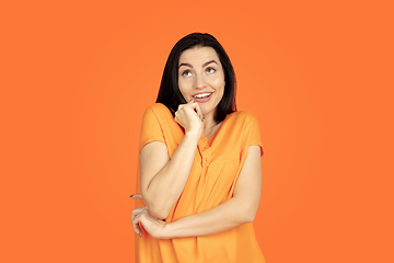 Image showing Caucasian young woman\'s portrait on orange background