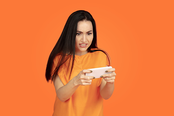 Image showing Caucasian young woman\'s portrait on orange background