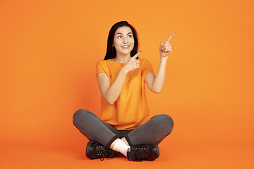 Image showing Caucasian young woman\'s portrait on orange background