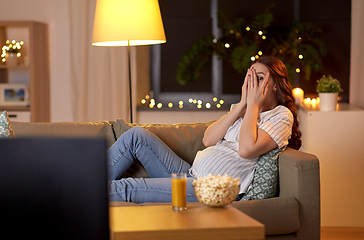 Image showing scared pregnant woman watching tv at home