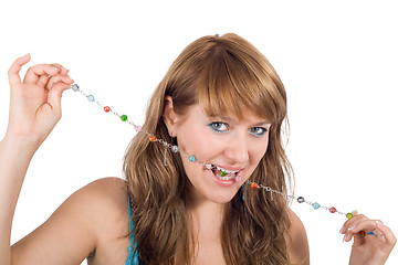 Image showing Portrait of the young beautiful woman with a beads in a teeth. I