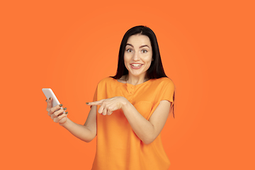 Image showing Caucasian young woman\'s portrait on orange background