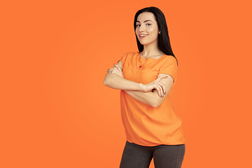 Image showing Caucasian young woman\'s portrait on orange background