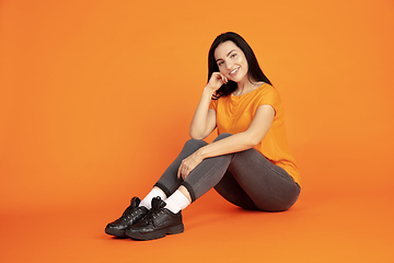 Image showing Caucasian young woman\'s portrait on orange background