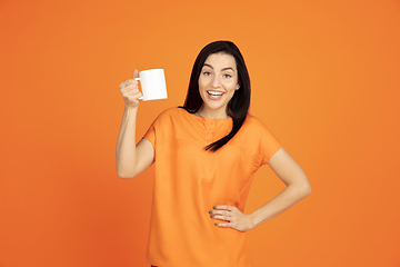 Image showing Caucasian young woman\'s portrait on orange background