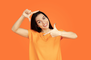 Image showing Caucasian young woman\'s portrait on orange background