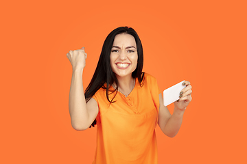 Image showing Caucasian young woman\'s portrait on orange background