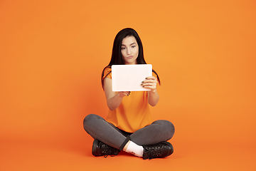 Image showing Caucasian young woman\'s portrait on orange background