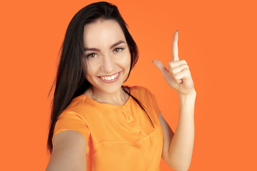 Image showing Caucasian young woman\'s portrait on orange background