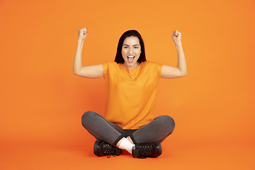 Image showing Caucasian young woman\'s portrait on orange background