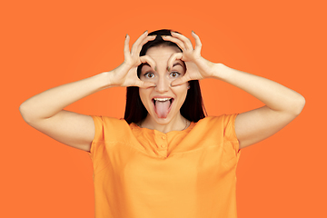 Image showing Caucasian young woman\'s portrait on orange background