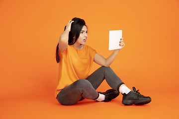 Image showing Caucasian young woman\'s portrait on orange background