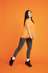 Image showing Caucasian young woman\'s portrait on orange background