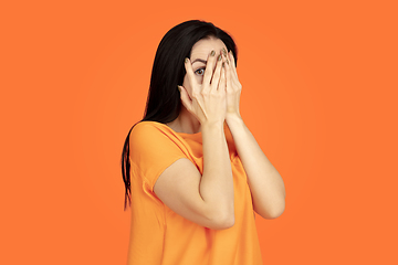 Image showing Caucasian young woman\'s portrait on orange background