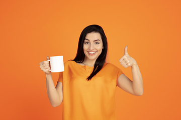 Image showing Caucasian young woman\'s portrait on orange background