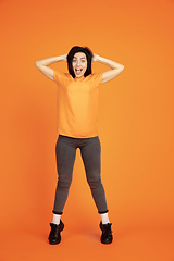 Image showing Caucasian young woman\'s portrait on orange background