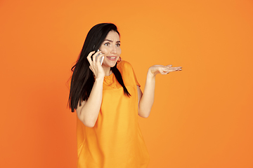 Image showing Caucasian young woman\'s portrait on orange background