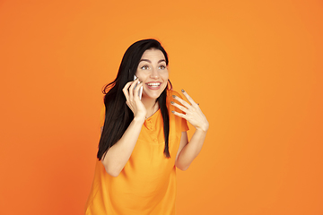 Image showing Caucasian young woman\'s portrait on orange background