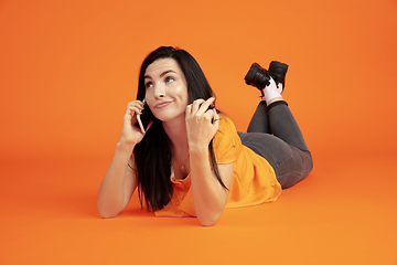 Image showing Caucasian young woman\'s portrait on orange background