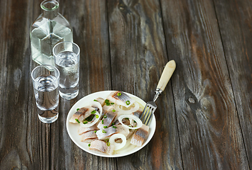 Image showing Vodka and traditional snack on wooden background