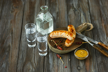 Image showing Vodka and traditional snack on wooden background