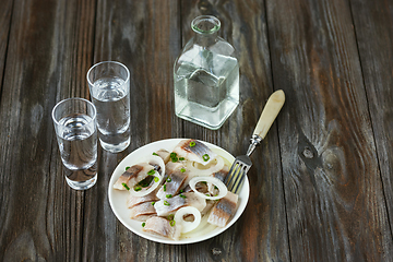 Image showing Vodka and traditional snack on wooden background