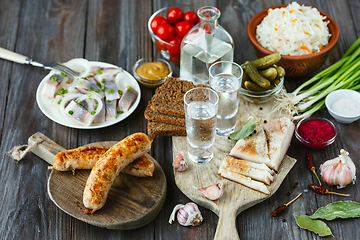 Image showing Vodka and traditional snack on wooden background