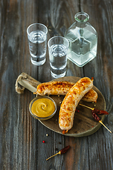 Image showing Vodka and traditional snack on wooden background