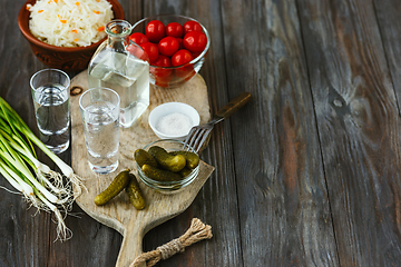 Image showing Vodka and traditional snack on wooden background