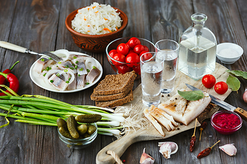 Image showing Vodka and traditional snack on wooden background