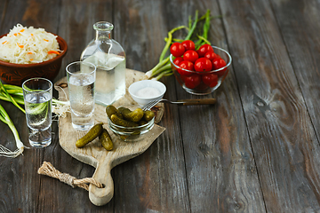 Image showing Vodka and traditional snack on wooden background