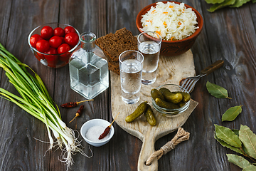 Image showing Vodka and traditional snack on wooden background