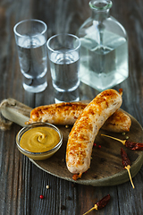 Image showing Vodka and traditional snack on wooden background