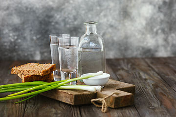 Image showing Vodka and traditional snack on wooden background