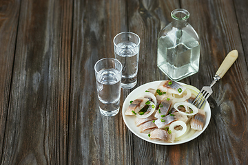 Image showing Vodka and traditional snack on wooden background