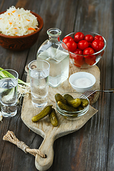 Image showing Vodka and traditional snack on wooden background