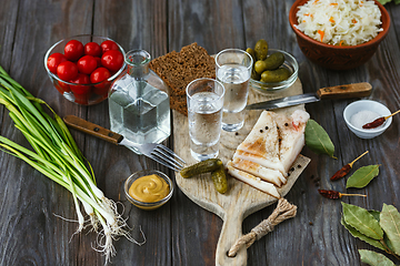 Image showing Vodka and traditional snack on wooden background